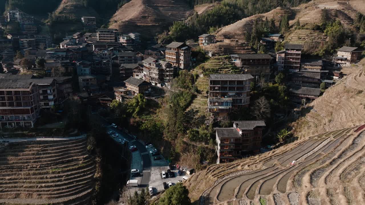 Drone shot showing Longsheng village and flooded rice terraces carved into the hillside near Guilin, Guangxi, China