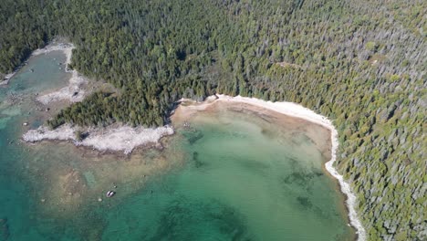 aerial-high-altitude-of-forested-rocky-lake-huron-coastline,-michigan