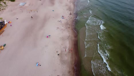 Toma-Aérea-De-La-Playa-Nublada,-Día-Nublado,-Tiro-Inclinado-Hacia-Arriba