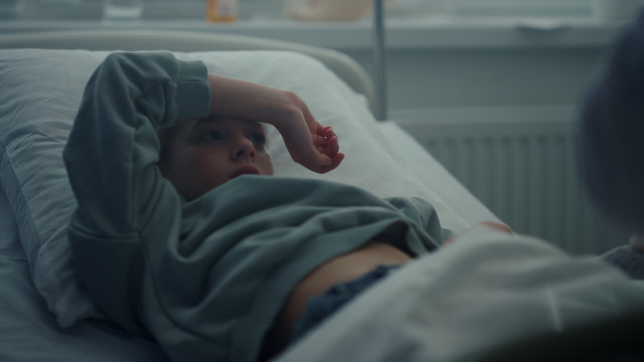 Little patient lying in clinic bed. Medical examination in hospital closeup.