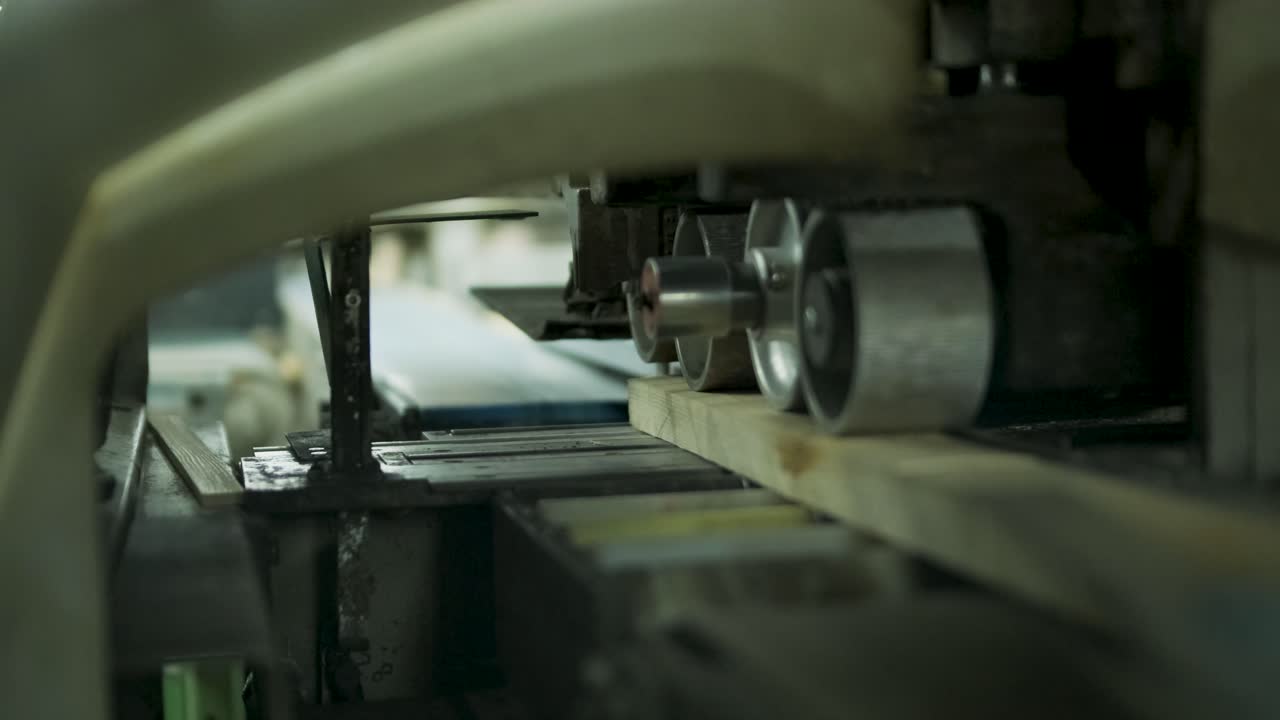 Automatiserad träbearbetningsmaskin som sågar plankor i en fabrik