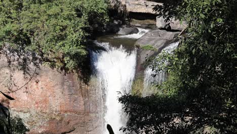agua cayendo en cascada por un acantilado rocoso en una piscina