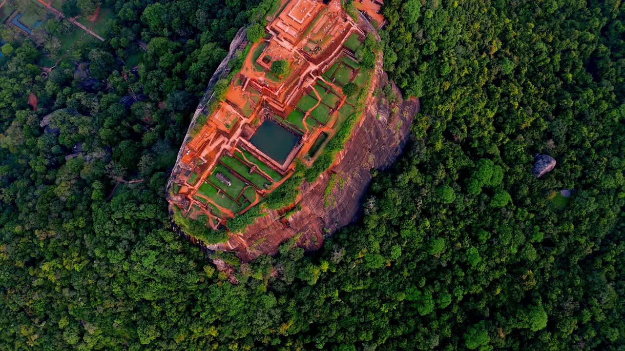 Aerial footage showcasing the iconic Sigiriya Rock Fortress rising dramatically above the surrounding jungle in central Sri Lanka.