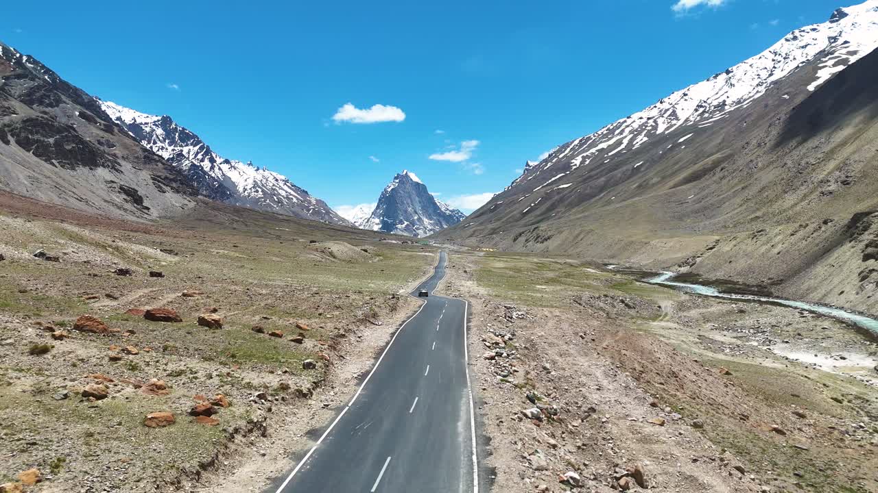 Aerial drone shot capturing the winding road leading up to Gombok Ranjan mountain.