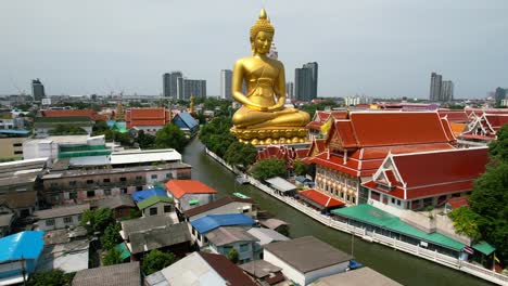 golden buddha statue wat paknam bhasicharoen in phasi charoen district in bangkok near chao phraya river cruise thailand - aerial pull back