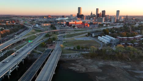 riverbank of arkansas river and aerial truck shot with tulsa skyline at dawn