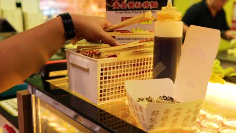 a person serves fried buns with sauce