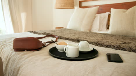 coffee and smartphone on bed with handbag, creating cozy morning atmosphere, at home