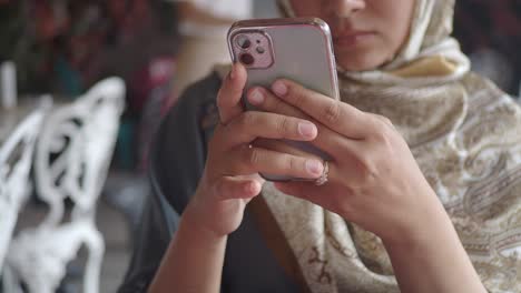 a woman in a hijab holding a smartphone