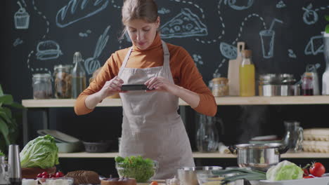 woman cooking and taking food photography in kitchen