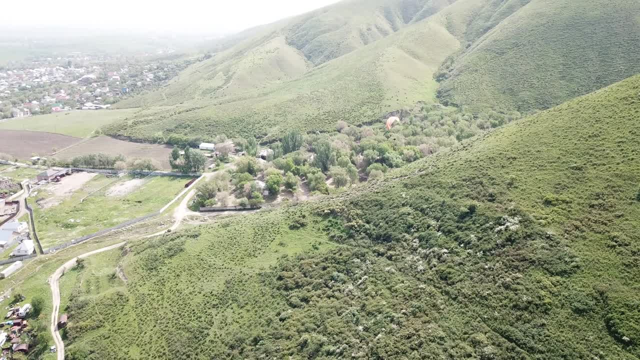 parapenteo en las montañas, campos verdes, colinas