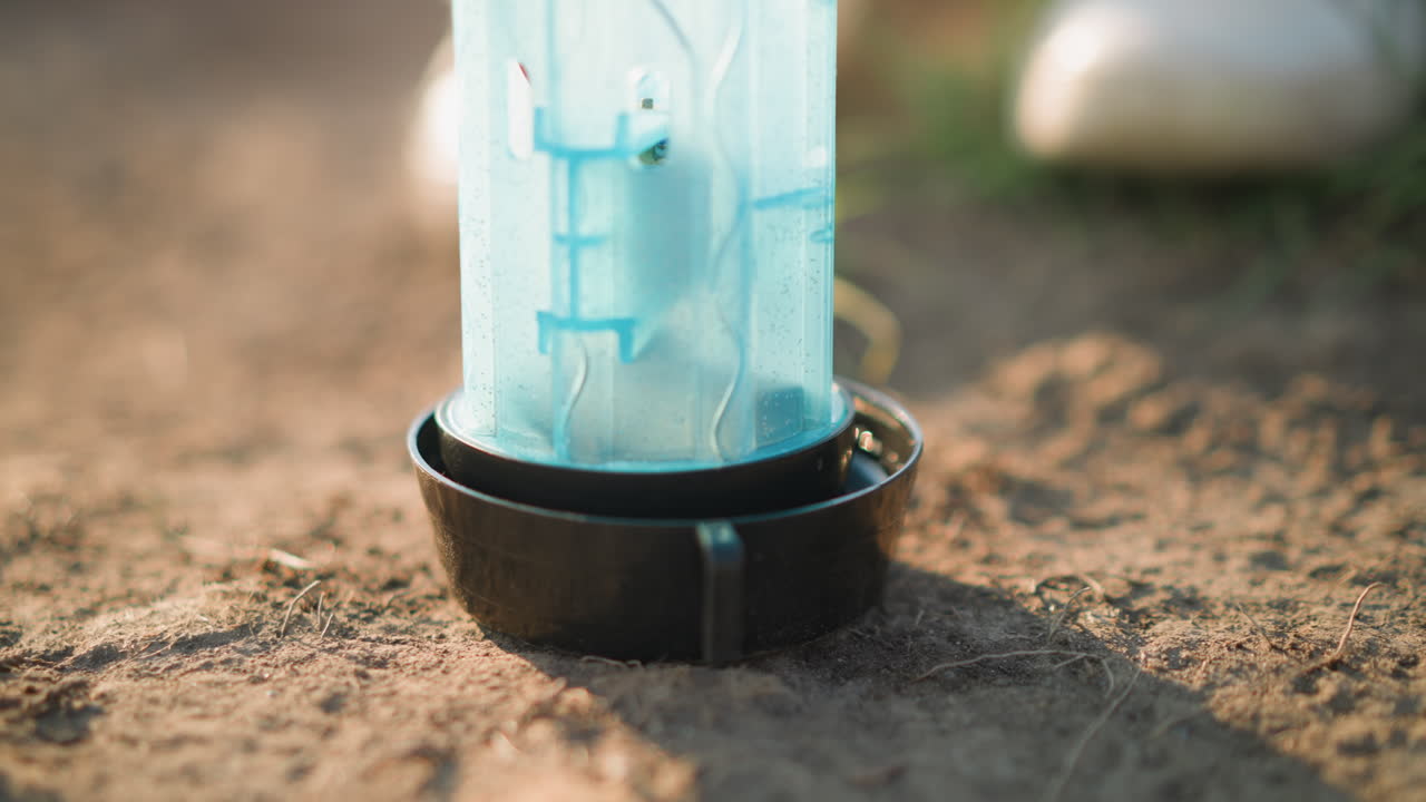 바닥에 있는 플라스틱 컨테이너의 클로즈업, 배경에는 잔디가 있고, 아마도 동물에게 먹이를 주거나 물을 주기 위해 사용되었을 것입니다.