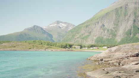 turquoise ocean with majestic mountainscape in background at lyngsdalen, norway