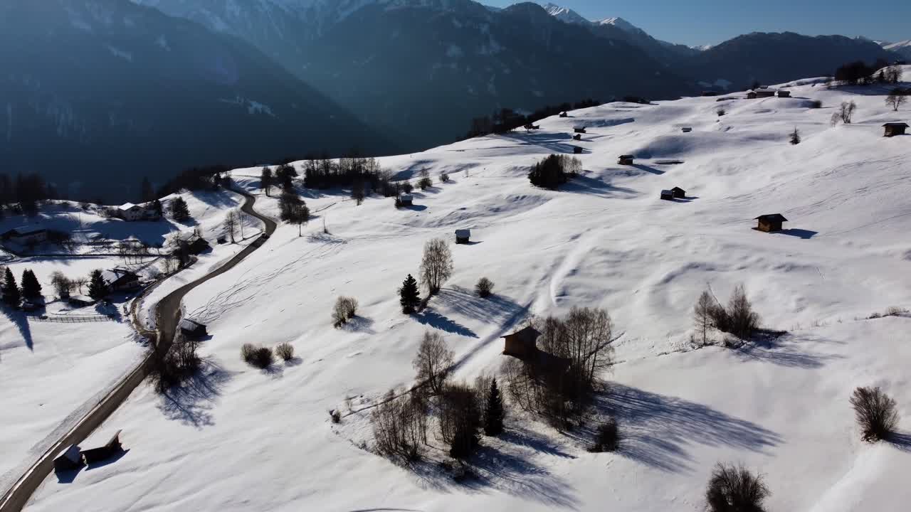 campo alpino con cabañas de madera durante la temporada de invierno nevada en un día soleado