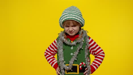 displeased girl in christmas elf santa helper costume looking unhappily angry, sad. negative emotion