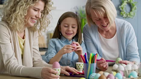 video of happy girl with family coloring easter egg