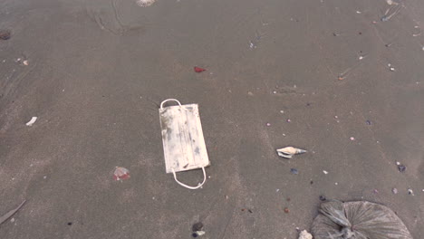 young-girl-throwing-disposed-face-mask-in-beach