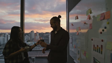 Guy-silhouette-thinking-evening-office-closeup.-Business-couple-drinking-coffee