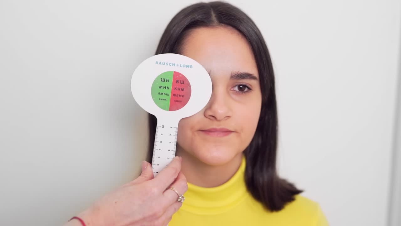 어린 소녀는 그녀의 나쁜 시력을 확인