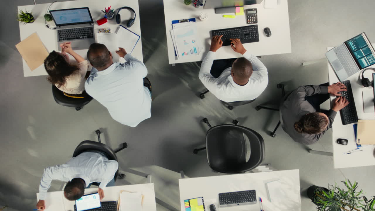 Top down view zoom in of professional workers focusing on performance metrics