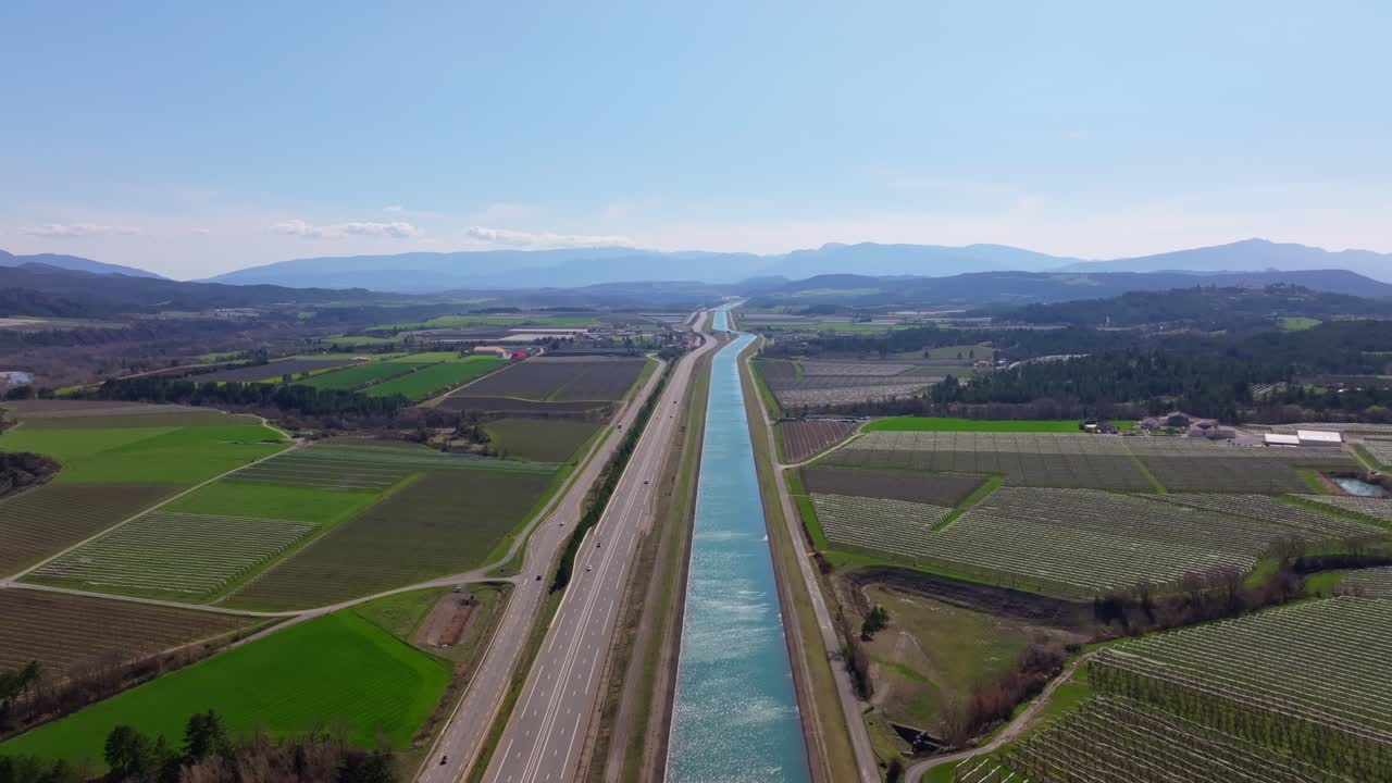 Un boschetto fiorito si trova tra l'ansa di un fiume e una strada di campagna