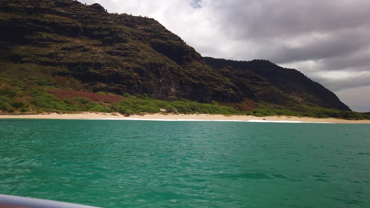 Gimbal wide panning shot from a boat along the rugged southern Na Pali coastline near Polihale Beach on the Hawaiian island of Kaua'i