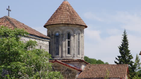 Stone-towers-of-Motsameta-monastery-above-trees-on-sunny-day,-Georgia