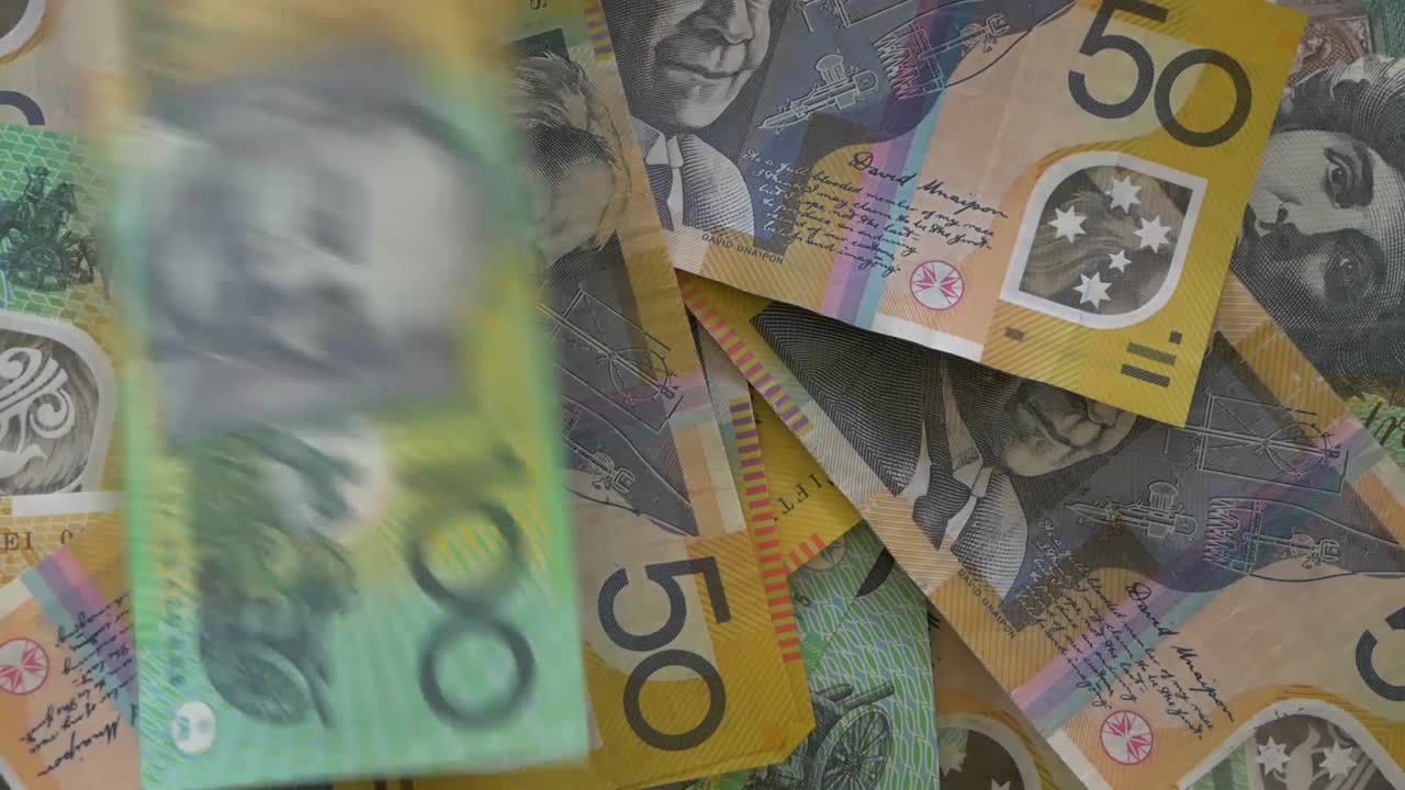 primer plano del dinero australiano cayendo sobre la mesa, la moneda cayendo