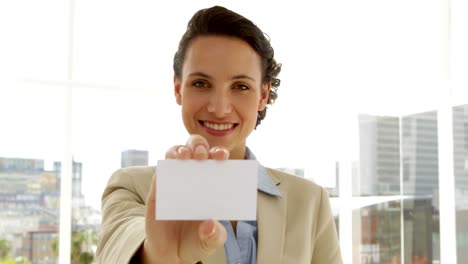 smiling businesswoman showing her card