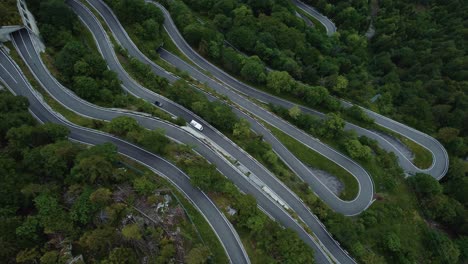 flying above the idyllic mountain serpentine road plöckenpass in the natural austrian and italian alps in summer with green forest trees and cars on the street