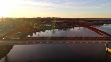 aerial view of a red arch bridge at sunset