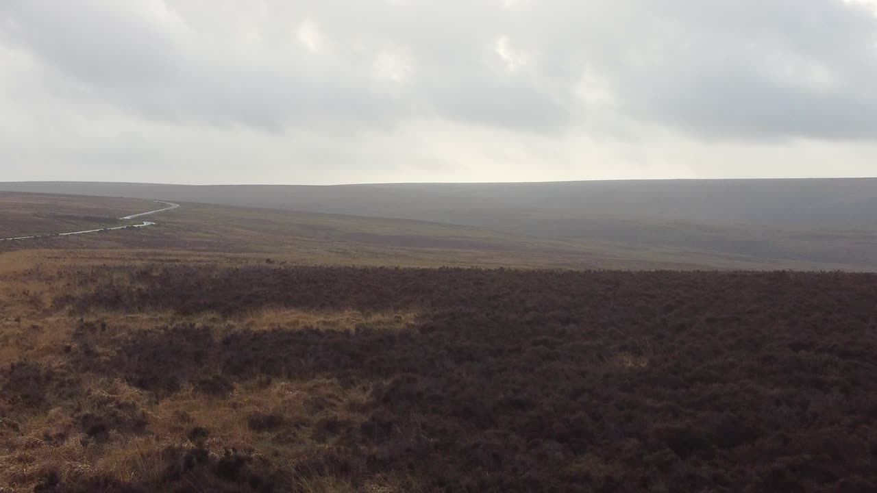 páramo con sinuosa carretera de campo y espectacular paisaje de nubes - vista aérea
