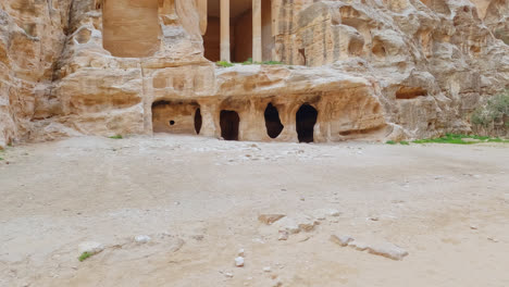 revealing shot of the ruins of a building carved in sandstone in petra