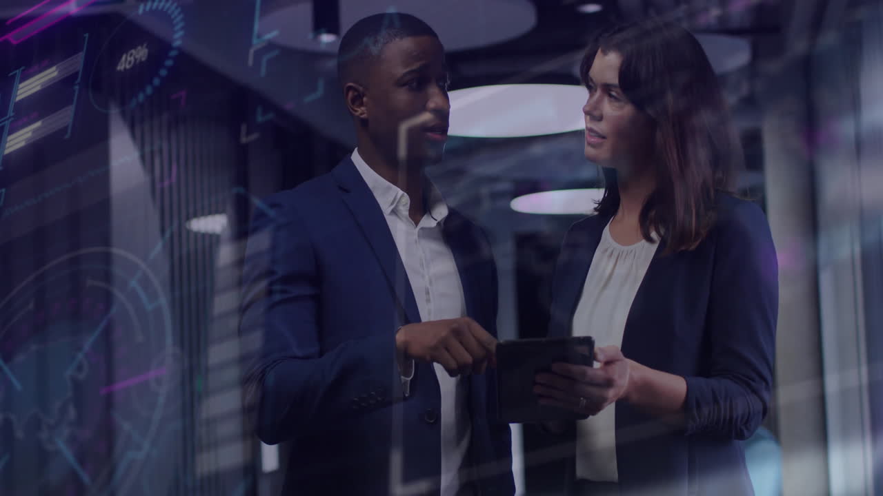 Two professionals reviewing tablet in tech office, showing floating digital graphs and interface