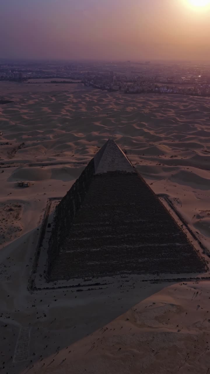 Aerial video captures a pyramid at sunset, highlighting its grandeur and the vast surrounding desert