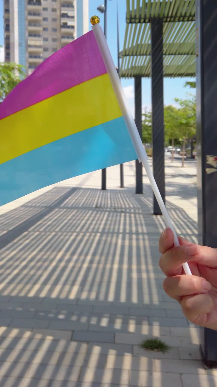 Pansexual pride flag waving in urban setting