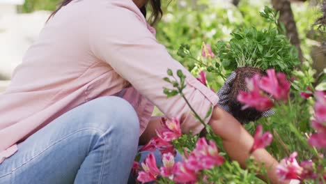 side view of biracial woman gardening, planting flowers