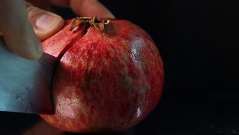 Cortando-La-Fruta-De-Granada-Por-La-Mitad-Y-Mostrando-Semillas-Sobre-Fondo-Negro