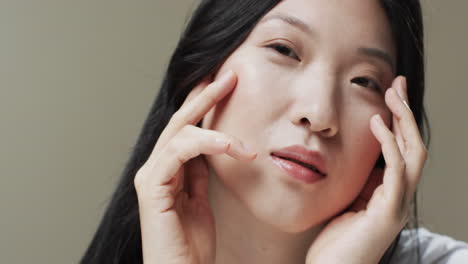 검은 머리카락과 메이크업을 가진 아시아 여성 만지는 얼굴, 복사 공간, 느린 동작