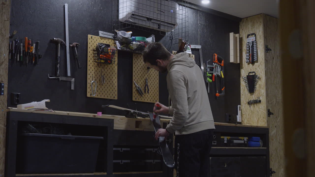 Man in his workshop applying ski wax to alpine skis. Static