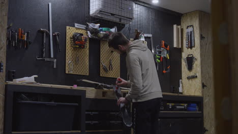 man in his workshop applying ski wax to alpine skis. static
