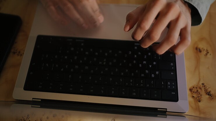 A Person Typing on a Laptop at a Desk