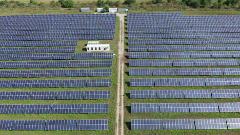 Sobrevuelo-Inverso-De-Antena-Baja-Sobre-Paneles-Solares-Que-Forman-Una-Gran-Granja-Solar