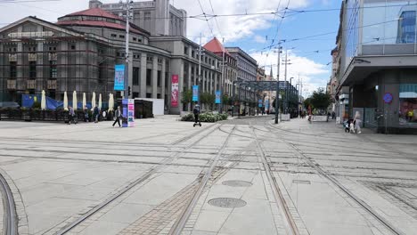 daytime view of a city street with tram tracks and historic buildings