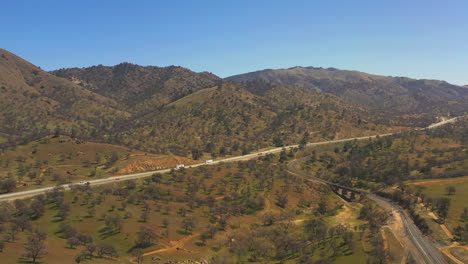 vista aérea de una carretera que atraviesa las montañas tehachapi en el borde del desierto de mojave del sur de california - cámara lenta