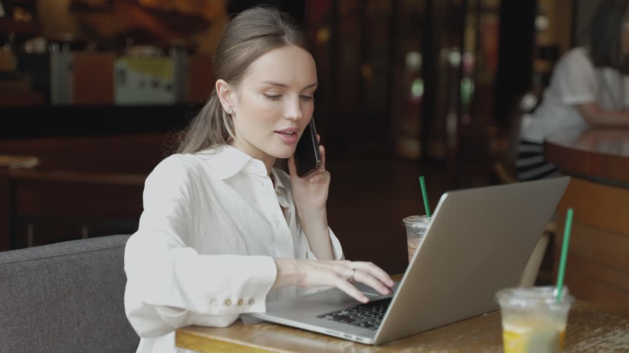Donna che lavora al computer portatile in un caffè