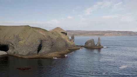 Volando-Hacia-Las-Pilas-De-Mar-De-Raudanes-Point-Junto-Al-Mar-En-Calma-En-Islandia