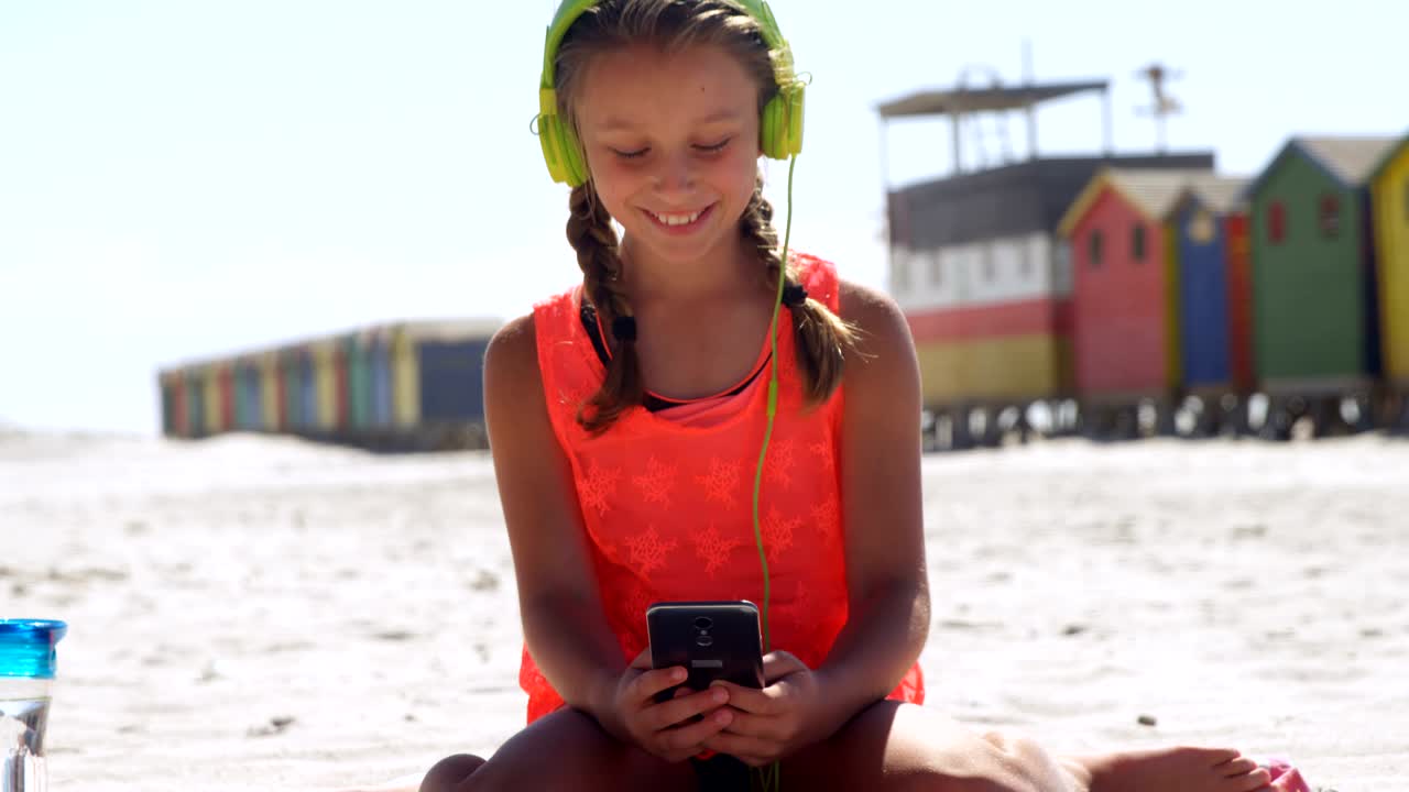 해변에서 휴대폰을 사용하는 소녀 4k