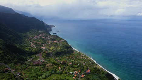 Drone-shot-revealing-breathtaking-views-of-Arco-de-Sao-Jorge-city-by-the-ocean-coast-in-Madeira-Island