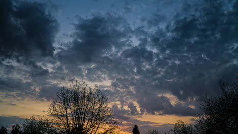 Colorful-Sunrise-through-fast-moving-clouds,-time-lapse